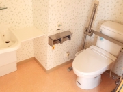 個室内のトイレです。手すりは低めの洗面台など、工夫が凝らされています。